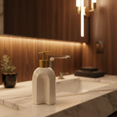 Dispensador de jabón cerámico blanco con diseño geométrico y bomba dorada