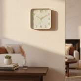 Reloj cuadrado de pared color dorado con números en relieve