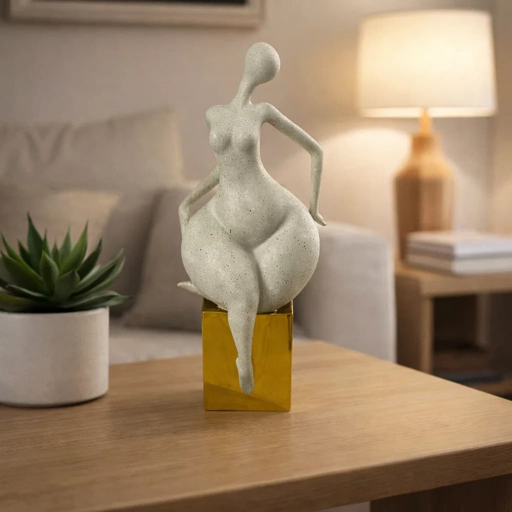 Figura decorativa mujer abstracta sentada con base dorada