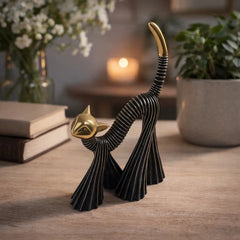 Gato decorativo negro con cabeza y cola dorada en posición de estiramiento