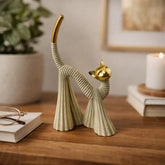Figura decorativa gato beige con cabeza y cola dorada en posición de estiramiento