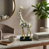 Figura decorativa jirafa dorada 38×12 cm con diseño de manchas y base negra