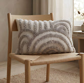 Cojín Rustic 156 marfil 30×50 cm rectangular con diseño de arcos en relieve sobre silla de madera