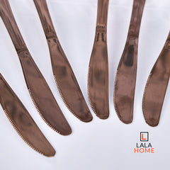 Set de cuchillos oro rosa x6 unidades sobre plato blanco – Alana Hogar.