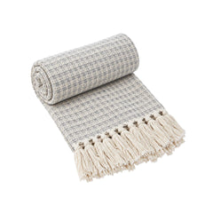 Frazada decorativa Masái 136 gris de 125 × 150 cm con flecos blancos.