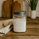 Recipiente de cristal cuadrado con líneas texturizadas y tapa plateada