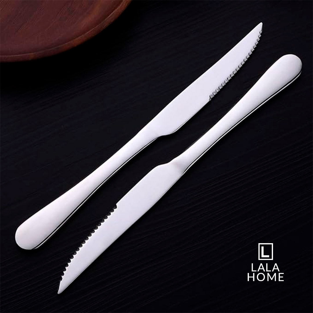 Set de 6 cuchillos de acero inoxidable plateados con filo dentado sobre fondo oscuro.