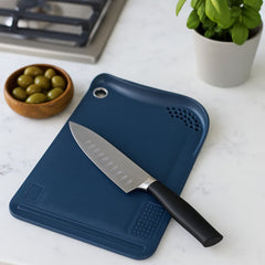 Tabla para picar de 33×23 cm en color azul oscuro con superficie texturizada y orificio para colgar.
