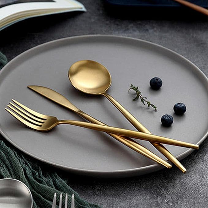 Set de 6 cucharas doradas New York sobre plato gris – diseño elegante.
