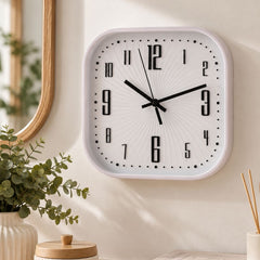Reloj de pared cuadrado blanco con números negros y manecillas negras