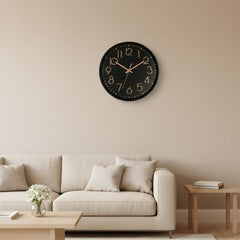 Reloj redondo de pared con fondo negro y números oro rosa