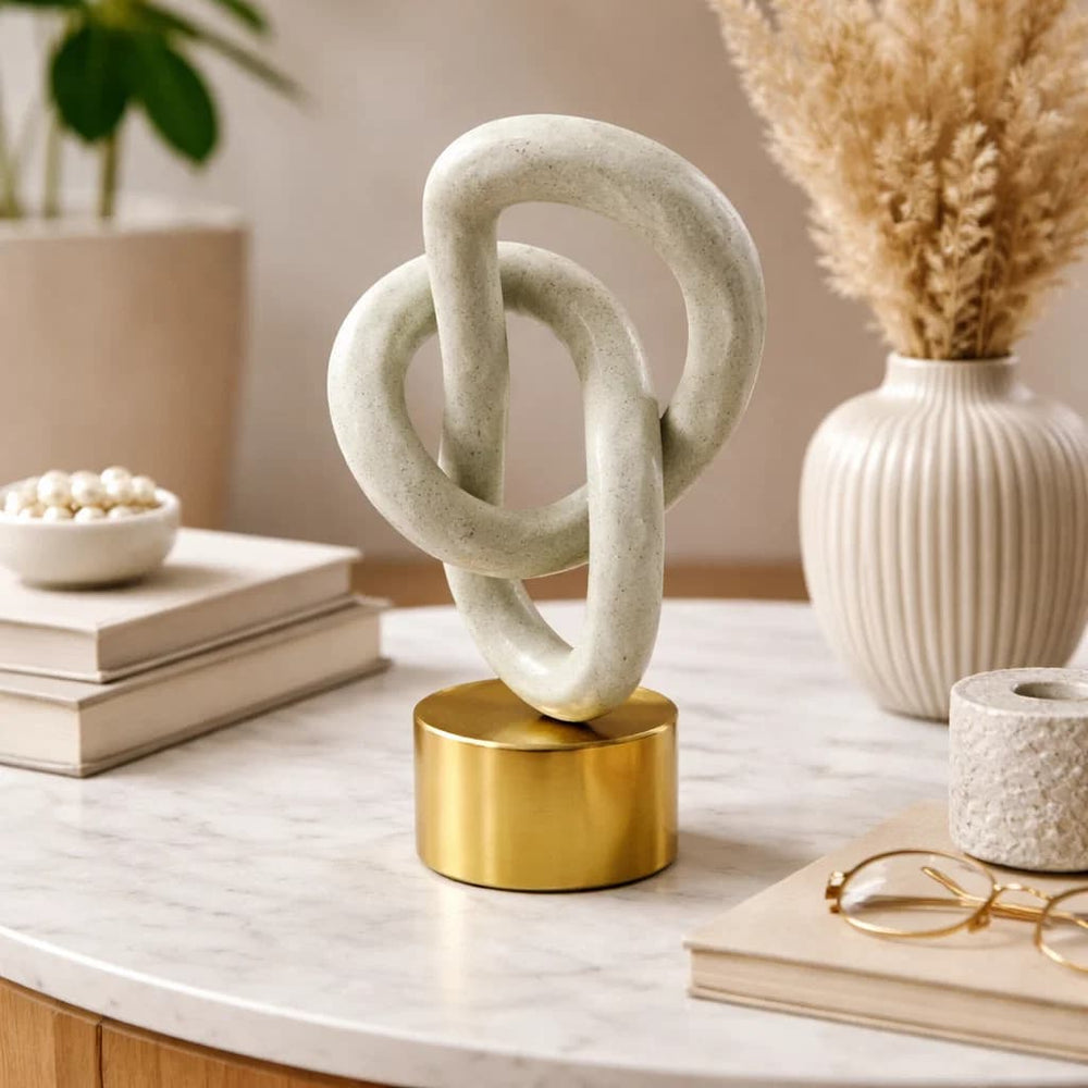 Figura decorativa abstracta entrelazada blanca con base dorada