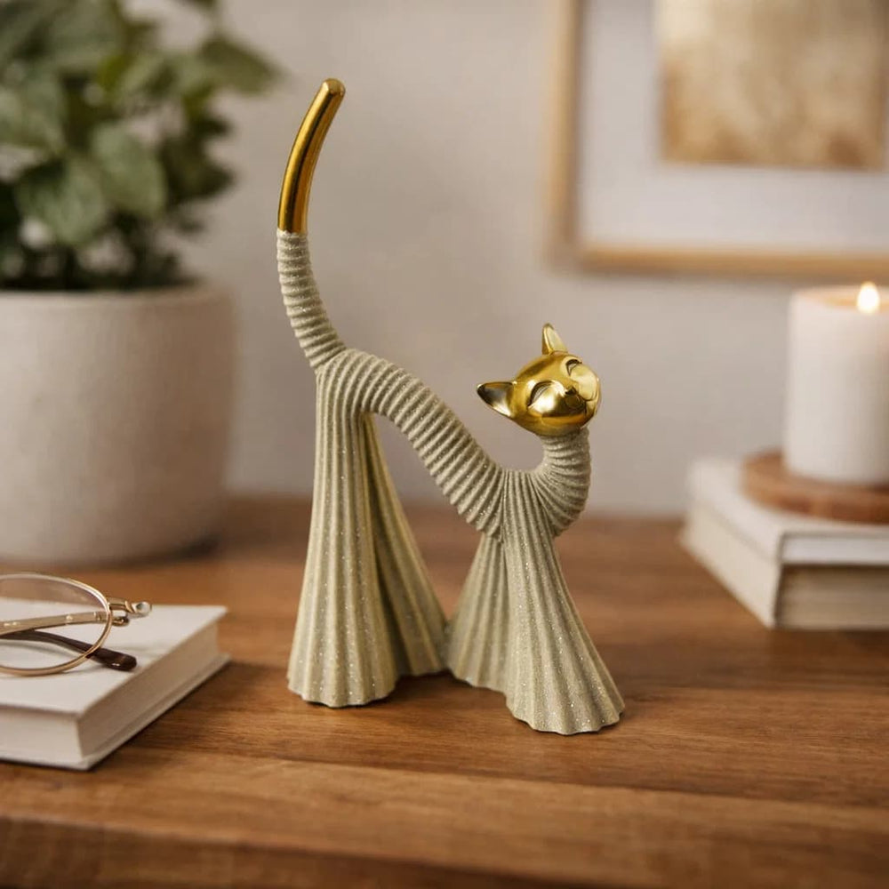 Figura decorativa gato beige con cabeza y cola dorada en posición de estiramiento