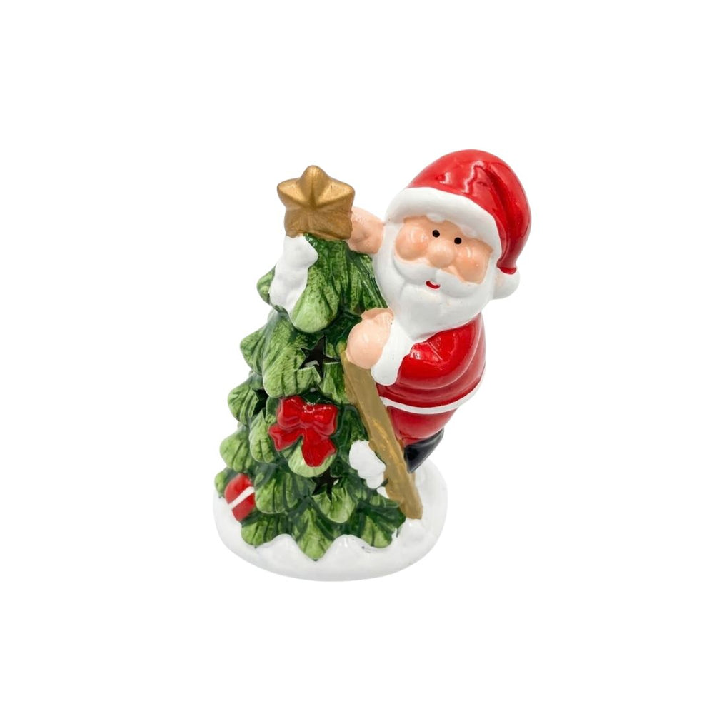 Figura navideña de Papá Noel junto a árbol verde