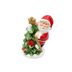 Figura navideña de Papá Noel junto a árbol verde