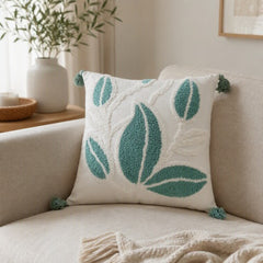 Cojín decorativo blanco 45×45 cm con hojas verdes texturizadas y borlas en las esquinas
