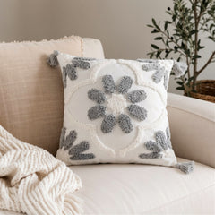 Cojín decorativo blanco y gris 45×45 cm con diseño de flor texturizada y borlas