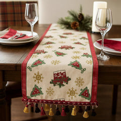 Camino de mesa navideño beige con borde rojo y borlas decorativas en tonos dorado, rojo y negro