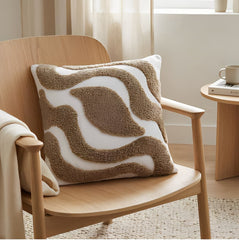 Cojín Rustic Boucle 152 beige 45×45 cm con diseño abstracto en relieve sobre butaca de madera