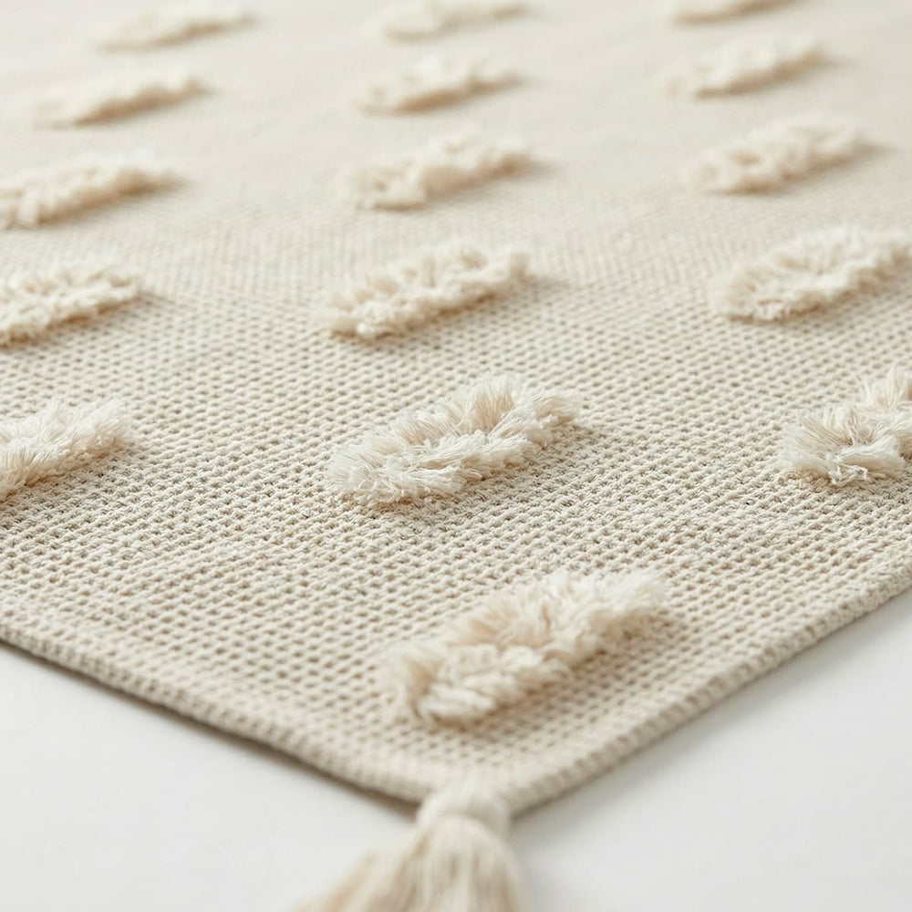 Manta decorativa taupe con borlas en las esquinas

