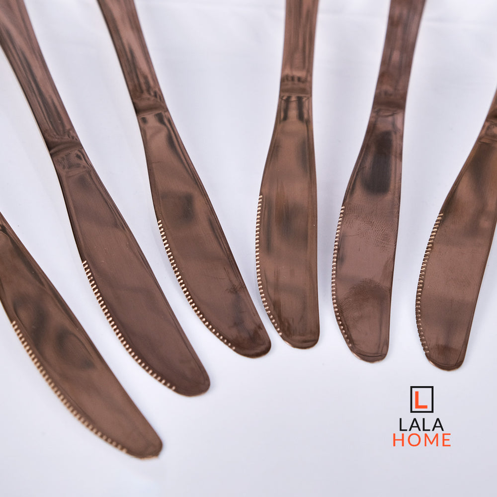 Set de cuchillos oro rosa x6 unidades sobre plato blanco – Alana Hogar.