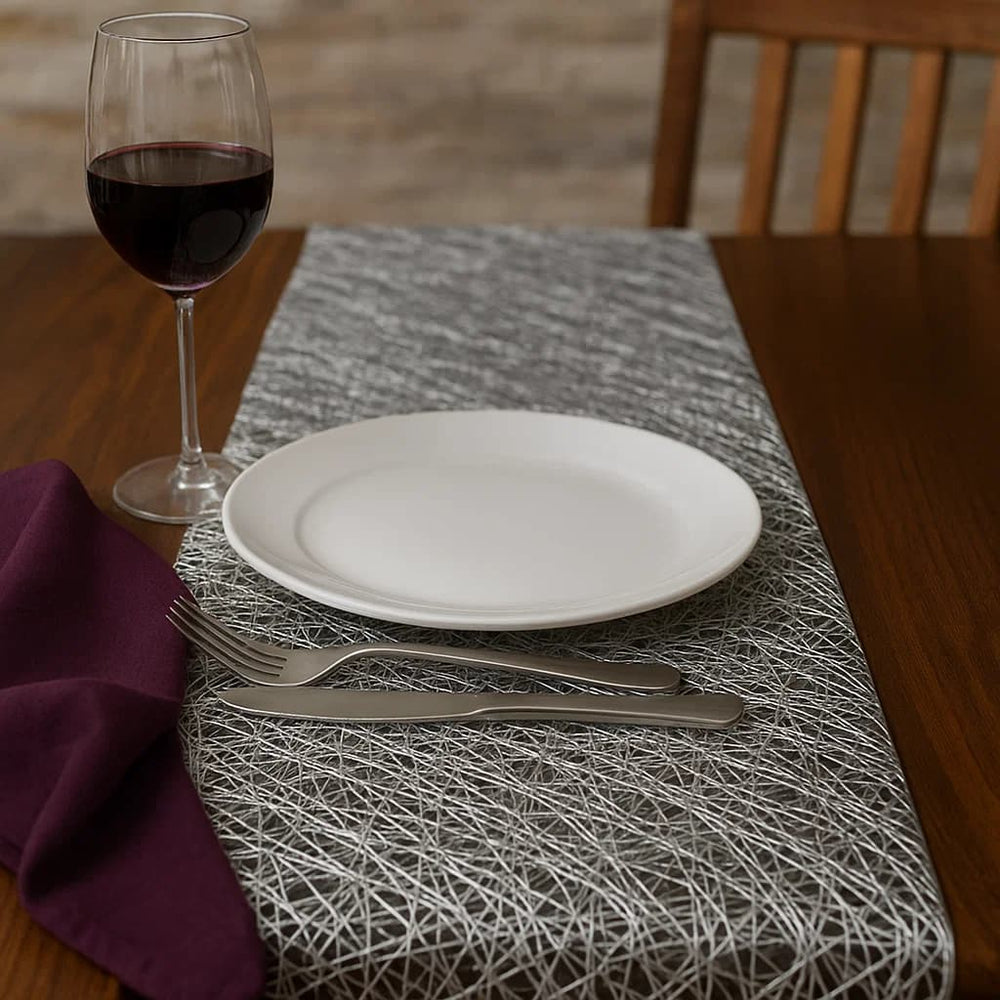 Camino de mesa gris plata en PVC con diseño moderno de trazos entrelazados