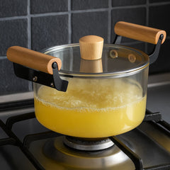 Olla de vidrio transparente de 2.5 L con tapa y mangos de madera natural sobre soporte metálico.